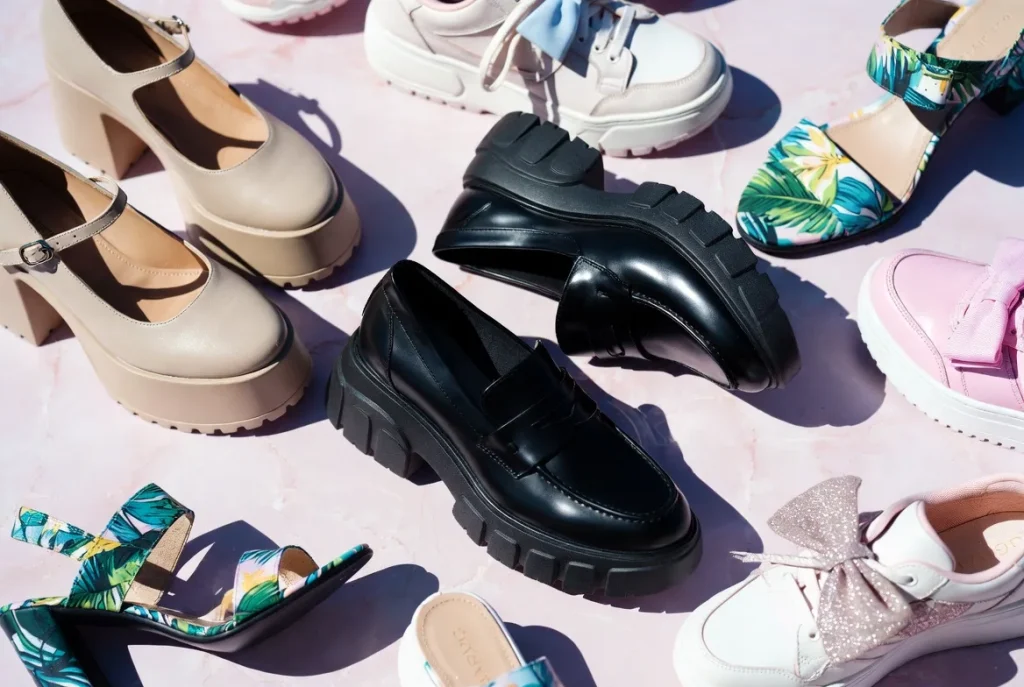 Flat lay of iconic Gyaru shoes collection including platform Mary Janes, loafers, sandals and bows on pink marble