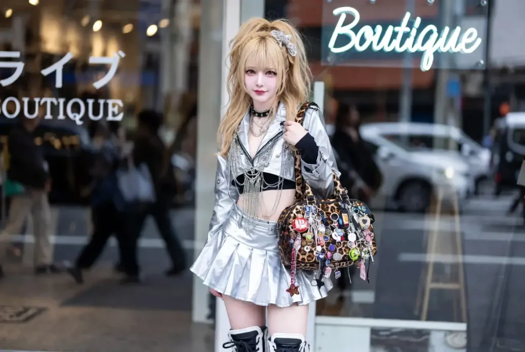メタリックのミニスカート、レイヤードチェーン、アニマル柄のバッグを身につけたネオギャル風の若い女性。